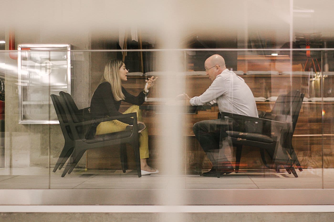 Duas pessoas em uma conversa de atendimento e negociação em um escritório de São Paulo.